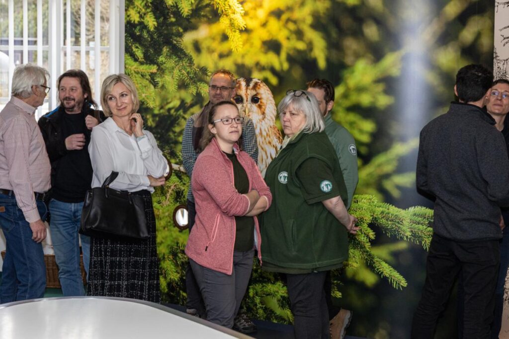 otevreni IS Kvilda po rekonstrukci, za hosty vernisáže je na stěně vidět velkoformátová fotografie s detailem sovy